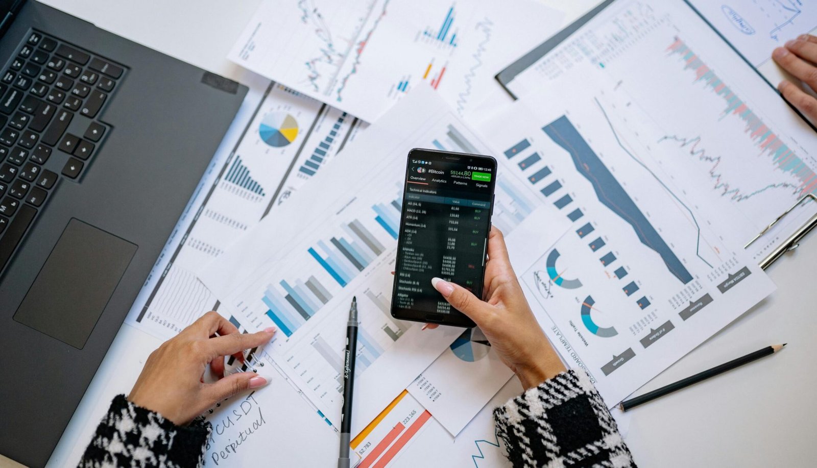 A top view on charts and smartphone in an office, showcasing data analytics.